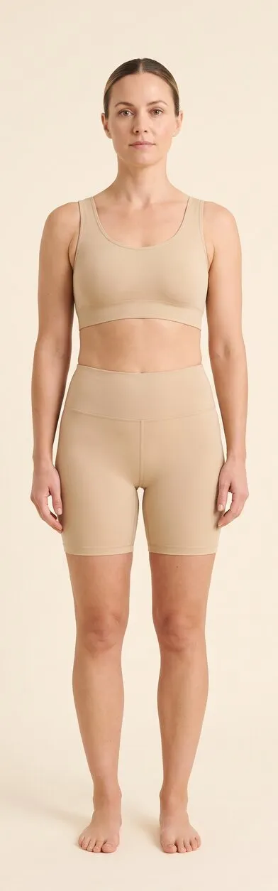 Body. Full-length front-facing photograph of a woman standing in plain activewear, used as a reference plate for the body areas the treatment reaches. Marked areas: 6 inner arms, 7 abdomen, 8 inner thighs, 9 knees, 10 love handles.