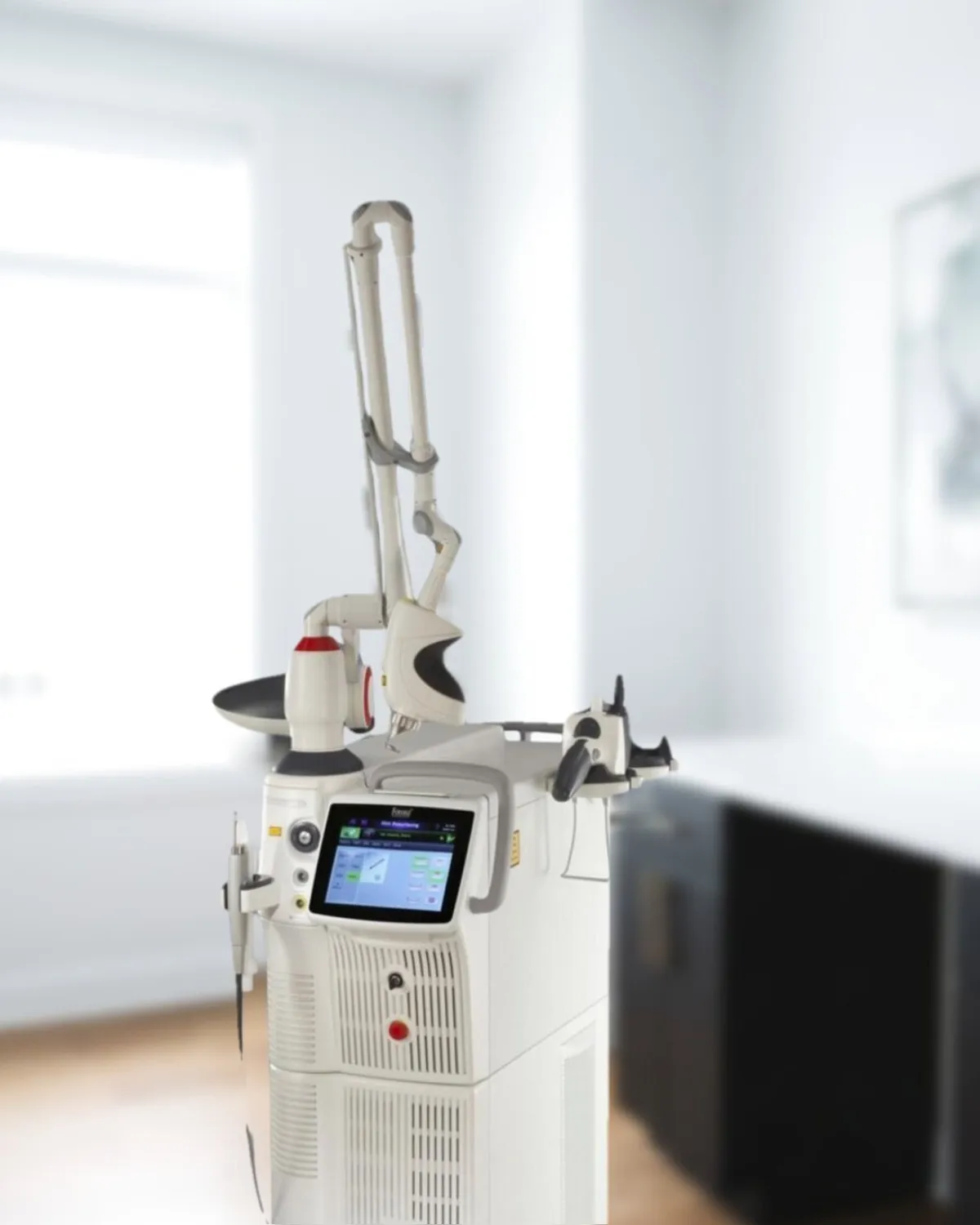 The practice's Fotona SP Dynamis dual-wavelength laser platform standing in a Medrein treatment room