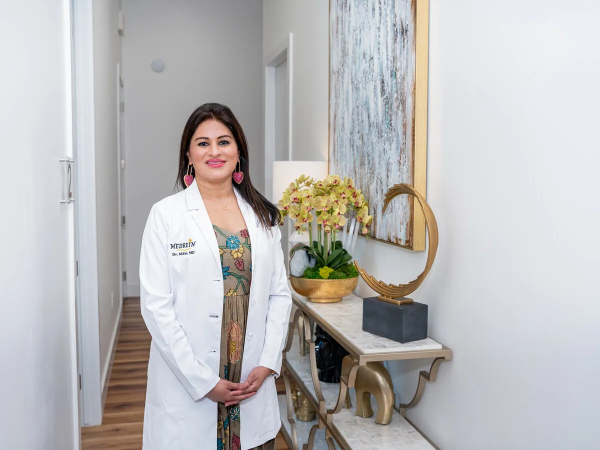 Dr. Haritha Mikkilineni, MD, in her lab coat during a consultation at the Medrein Health clinic in Southlake, TX