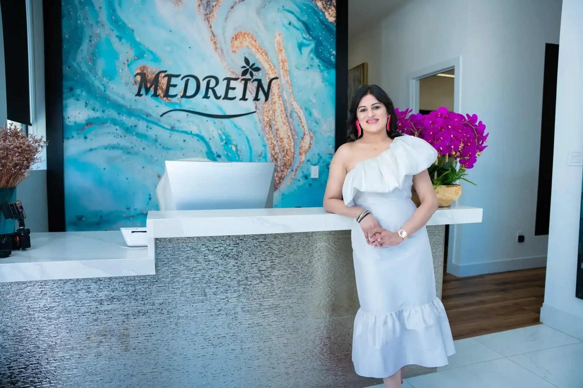 Dr. Haritha Mikkilineni at the Medrein Health & Aesthetics reception desk in Southlake, TX