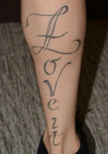 Calf before laser tattoo removal, showing black script running the length of the leg