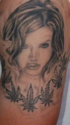 Upper arm before laser tattoo removal, showing a large black-and-grey portrait piece with leaf work below it