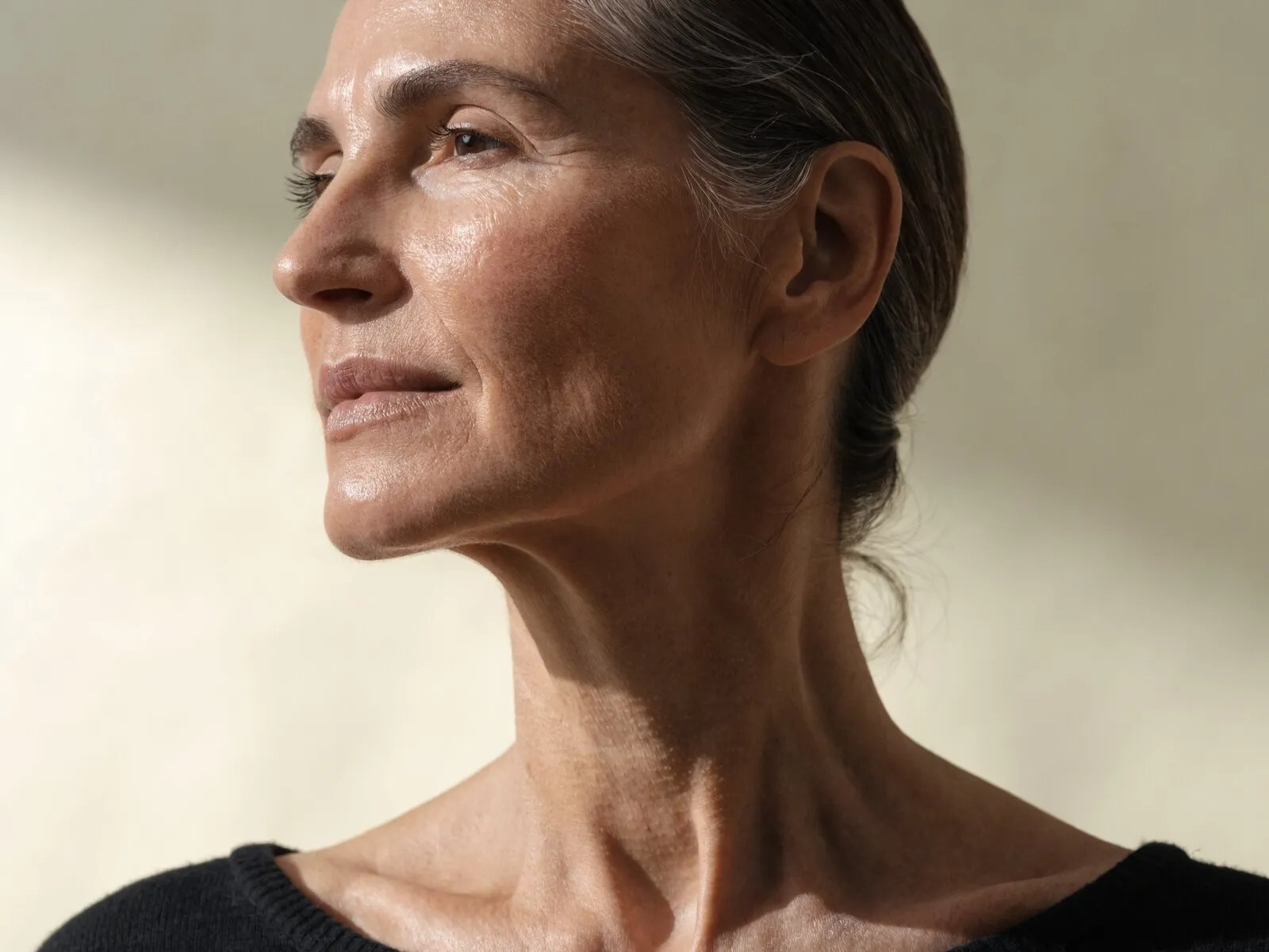 Near-profile view of a woman with her chin lifted, her jaw line and neck unobstructed — the area the deeper Fotona 4D passes are aimed at