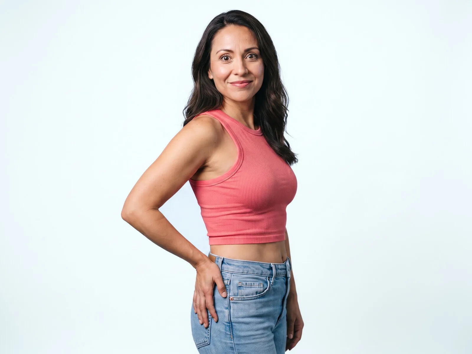 A woman standing with a hand resting on her upper hip, where hormone pellets are placed under the skin