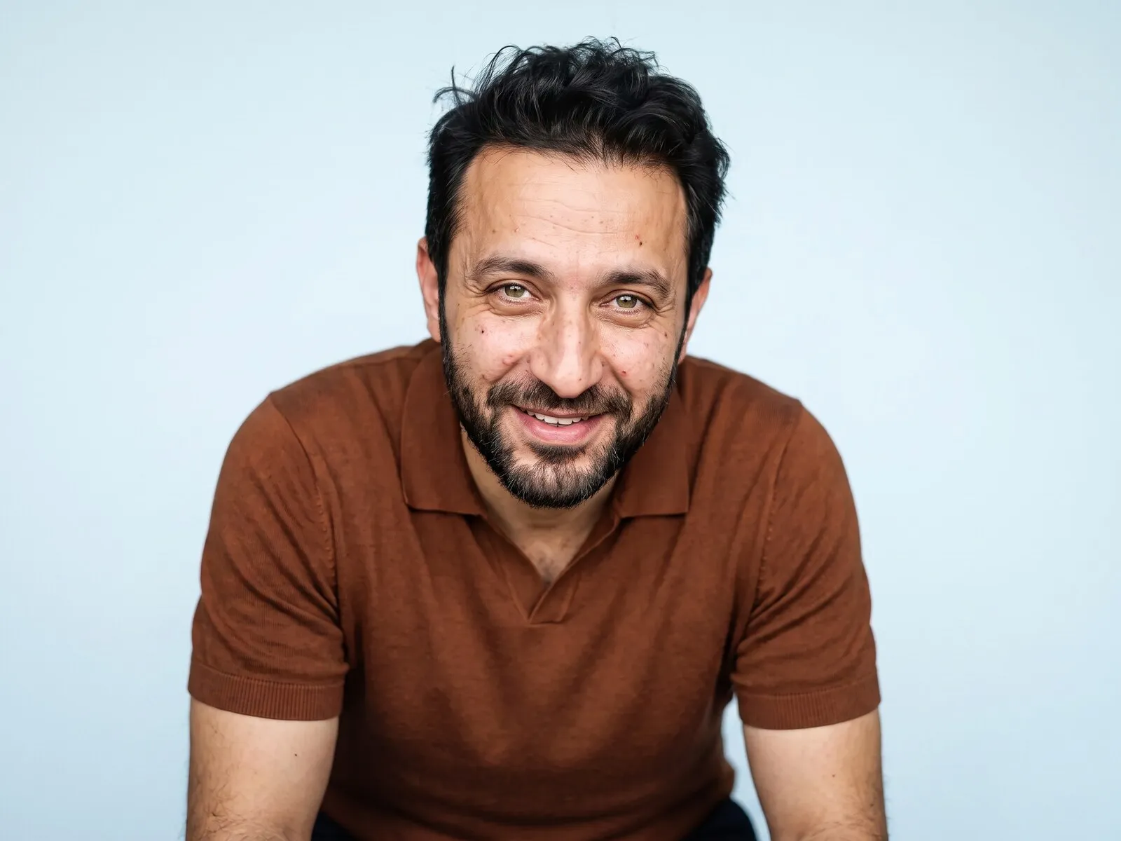 A man in his forties photographed alone against a pale blue ground, representing the private, one-to-one consultation behind sexual wellness peptide therapy at Medrein Health